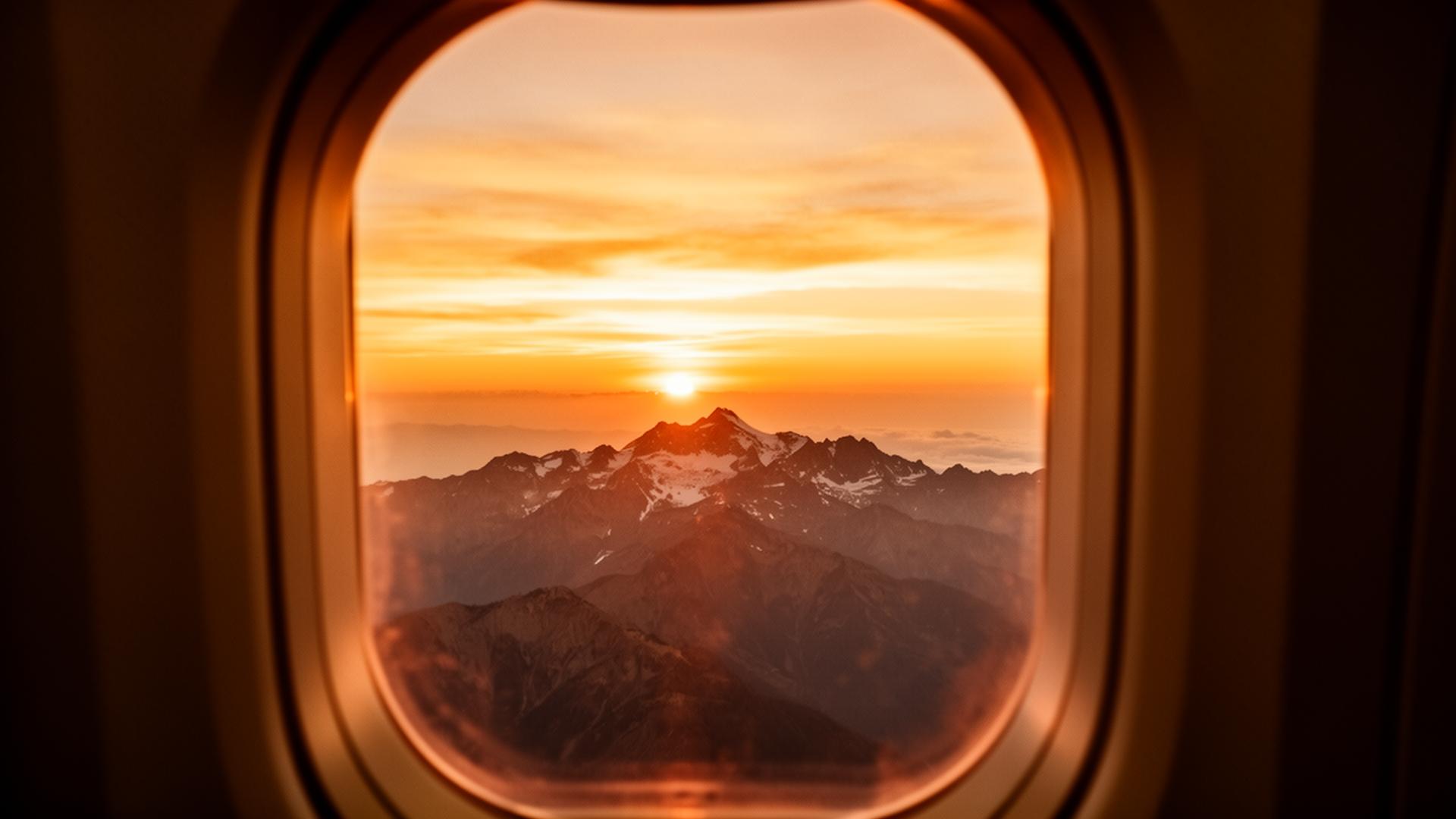 Sunset over a mountain range from a business class window